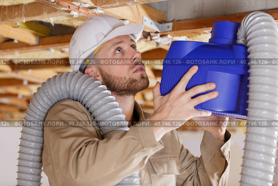 young male contractor installing an air conditioning unit. Стоковое фото, агентство Ingram Publishing / Фотобанк Лори