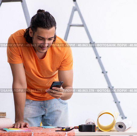 Young man contractor doing renovation at home. Стоковое фото, фотограф Elnur / Фотобанк Лори