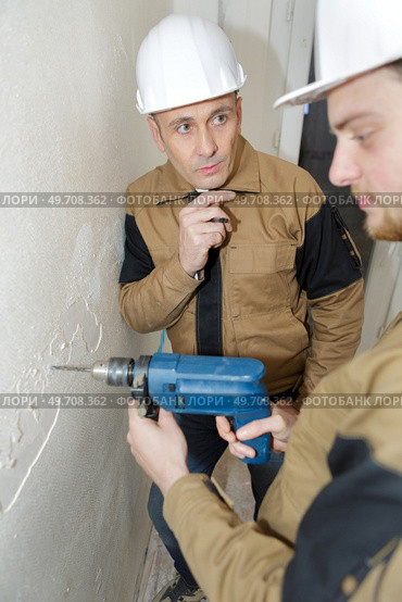 young man drilling the wall with drill perforator. Стоковое фото, агентство Ingram Publishing / Фотобанк Лори