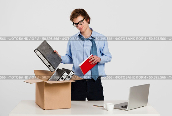 Young man in the office packing up after being fired. Стоковое фото, агентство Ingram Publishing / Фотобанк Лори