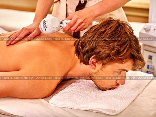 Young man receiving electric facial massage. Стоковое фото, фотограф Gennadiy Poznyakov / Фотобанк Лори