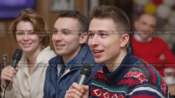 Young man speaking into microphone at a casual event. Стоковое AI-видео, аниматор Юрий Поздников / Фотобанк Лори