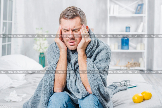 young man suffering from cold having headache. Стоковое фото, агентство Ingram Publishing / Фотобанк Лори