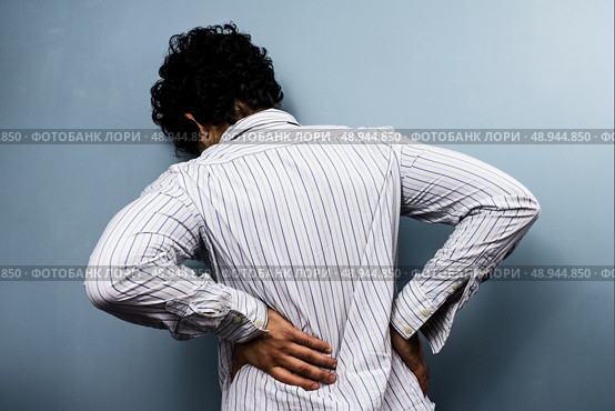 Young man with a sore back. Стоковое фото, агентство Ingram Publishing / Фотобанк Лори