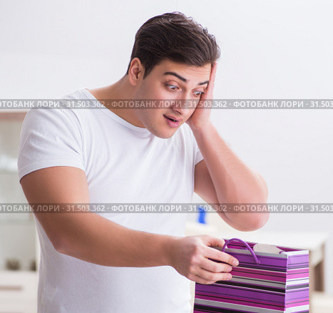 Young man with gift bag at home preparing suprise for wife. Стоковое фото, фотограф Elnur / Фотобанк Лори