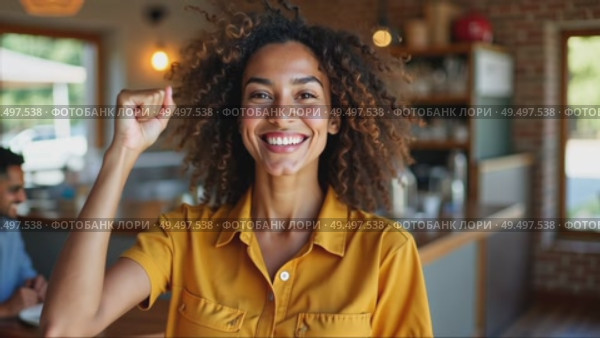 Young optimistic positive woman in color shirt excited of successful finished hard and difficult task or project. She standing in modern cozy cafe setting near her colleagues, her arm raised in fist. Стоковое AI-видео, аниматор Sergey Grishin / Фотобанк Лори