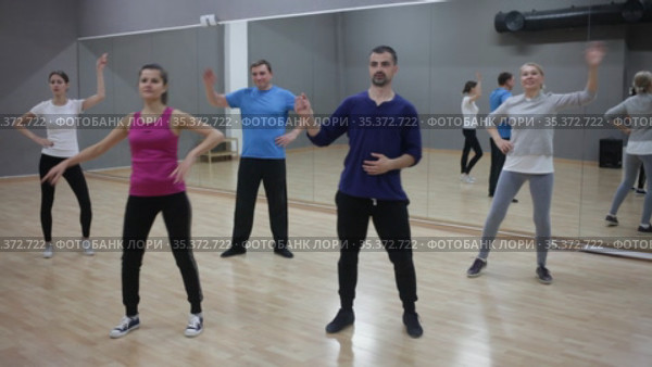 Young smiling woman practicing vigorous lindy hop movements in dance class. Стоковое видео, видеограф Яков Филимонов / Фотобанк Лори