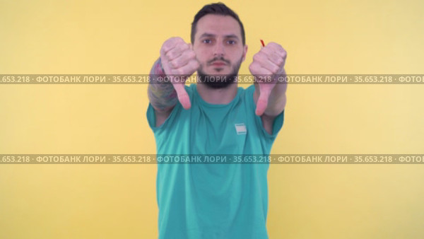 Young sporty man giving thumbs up and than giving thumbs down and shaking hand for no. Стоковое видео, видеограф Mihail Mihaylov / Фотобанк Лори