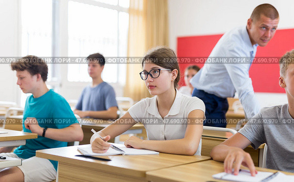 Young students sitting at desks in classroom. Стоковое фото, фотограф Яков Филимонов / Фотобанк Лори