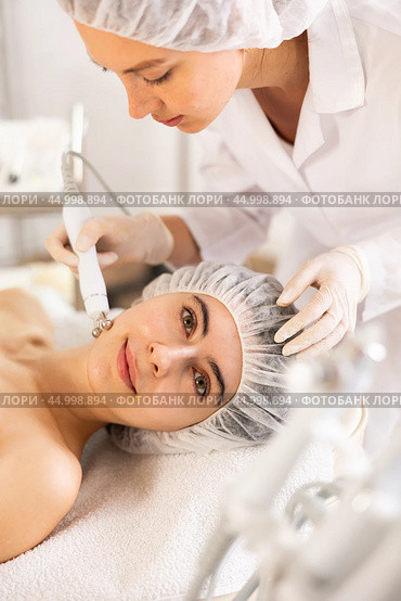 Young woman cosmetologist doing microcurrent procedure to young woman. Стоковое фото, фотограф Яков Филимонов / Фотобанк Лори