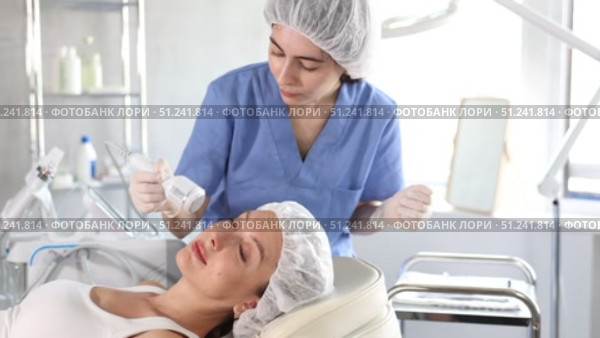 Young woman cosmetologist doing whitening procedure to young woman. Стоковое видео, видеограф Яков Филимонов / Фотобанк Лори
