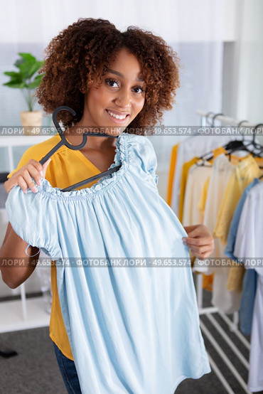 young woman deciding what to put on. Стоковое фото, агентство Ingram Publishing / Фотобанк Лори