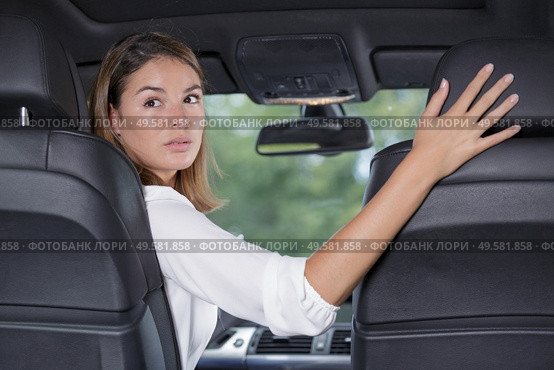 young woman driver reversing car. Стоковое фото, агентство Ingram Publishing / Фотобанк Лори