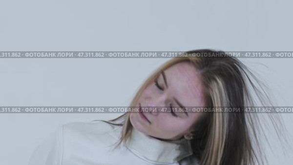 Young woman fencer in white suit takes off her protective helmet and releases her long beautiful hair. Стоковое видео, видеограф Константин Шишкин / Фотобанк Лори