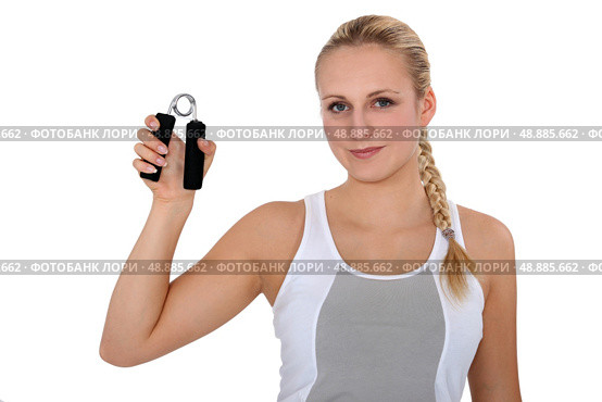 Young woman holding hand grippers. Стоковое фото, агентство Ingram Publishing / Фотобанк Лори