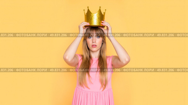 Young woman in pink dress placing gold crown on head, arrogant expression, satire concept, funny attitude, royal theme, humor scene, modern queen, playful mood, sarcastic fashion, confident pose. Стоковое AI-изображение, AI-художник Павел Муравьев / Фотобанк Лори