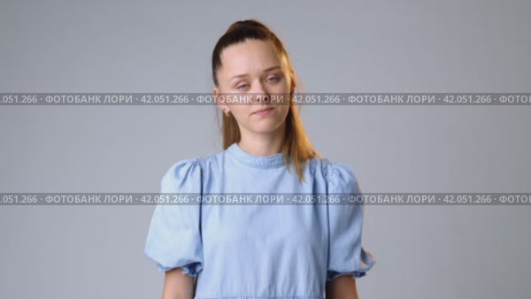 Young woman rejecting something with her hands on gray background. Стоковое видео, видеограф Сергей Толмачёв / Фотобанк Лори