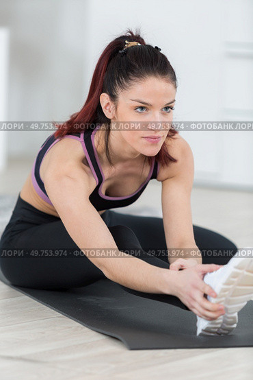 young woman stretching on the floor in the living room. Стоковое фото, агентство Ingram Publishing / Фотобанк Лори
