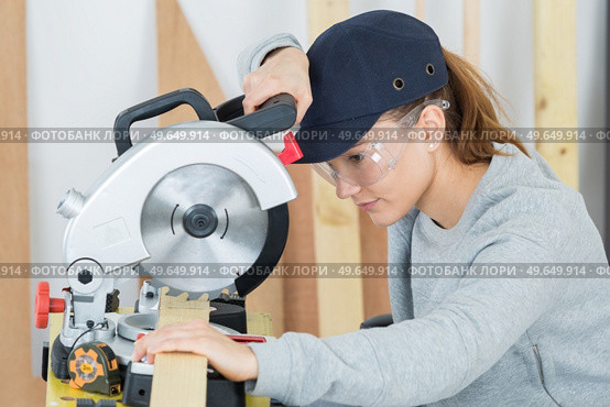 young woman using circular saw. Стоковое фото, агентство Ingram Publishing / Фотобанк Лори