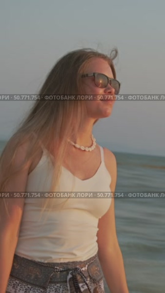 Young woman walking on beach at sunset. Стоковое видео, видеограф Михаил Коханчиков / Фотобанк Лори