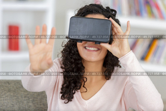 young woman wearing a virtual reality headset at home. Стоковое фото, агентство Ingram Publishing / Фотобанк Лори