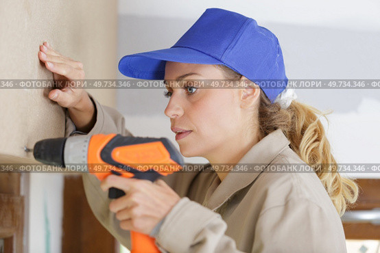 young woman with toolbelt using drill repair and renovation. Стоковое фото, агентство Ingram Publishing / Фотобанк Лори
