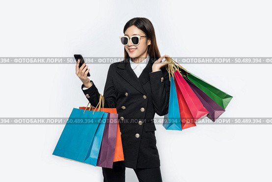 Young women wear glasses and shop on smart phones. Стоковое фото, агентство Ingram Publishing / Фотобанк Лори