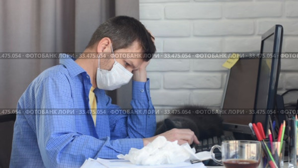 Заболевший сотрудник на карантине в медицинской маске работает в компьютере. Стоковое видео, видеограф Иванов Алексей / Фотобанк Лори