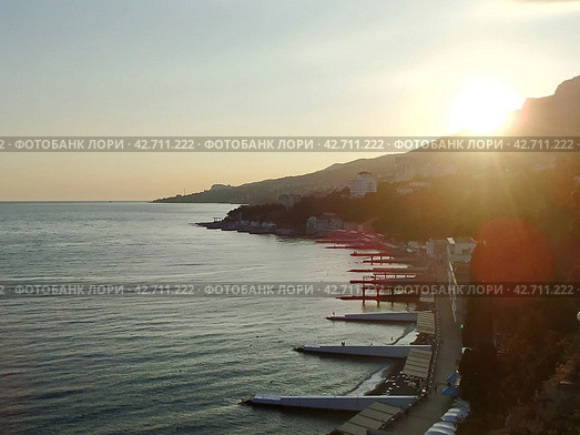 Закат над морем. Солнце опускается за Ай-Петри. Крымский пейзаж. Южный берег Крыма, Гаспра, Россия (2021 год). Стоковое фото, фотограф Сергей Елизарьев / Фотобанк Лори
