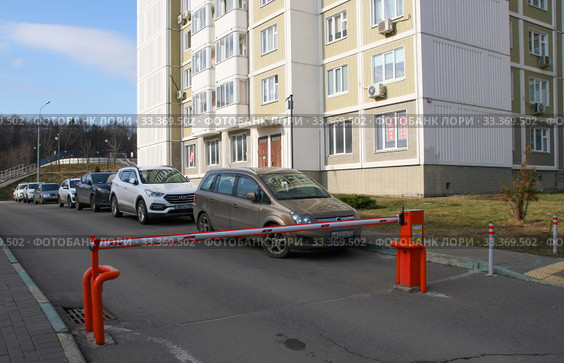 Закрытый шлагбаум на въезде во двор жилого дома (2020 год). Редакционное фото, фотограф Щеголева Ольга / Фотобанк Лори
