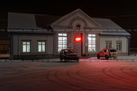 Железнодорожная станция Анзёби, город Братск, Иркутская область, Сибирь, Россия. Анзёби — это станция Байкало-Амурской магистрали (БАМ) на участке, входящем в состав Восточно-Сибирской железной дороги. Ночной вид на здание вокзала. Холодная зимняя погода. (2023 год). Редакционное фото, фотограф Андрей Степанов / Фотобанк Лори