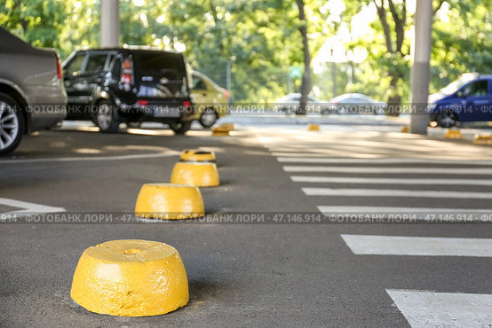 Желтые ограничители на парковке. Стоковое фото, фотограф Pixel_shot / Фотобанк Лори