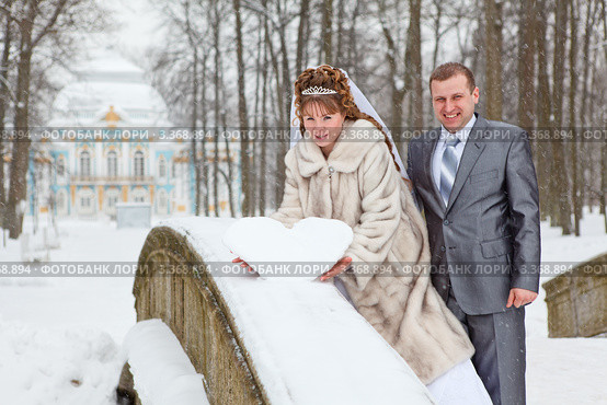 Жених и невеста около снежной формы в виде сердца. Стоковое фото, фотограф Кекяляйнен Андрей / Фотобанк Лори