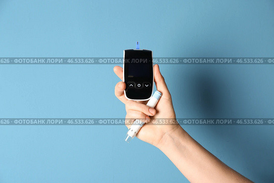 Женщина держа цифровую ручку glucometer и ланцета на предпосылке цвета. Контроль диабета. Стоковое фото, фотограф Pixel_shot / Фотобанк Лори