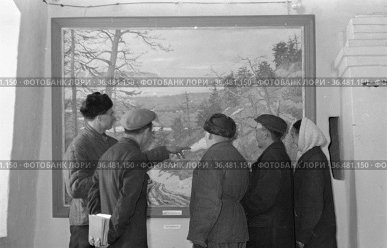 Женщина и несколько мужчин рассматривают картину с изображением северного пейзажа, люди стоят спиной к камере в музее изобразительного искусства "Навеки вместе", ноябрь 1957. Редакционное фото, фотограф Варфоломей Тетерин / Фотобанк Лори