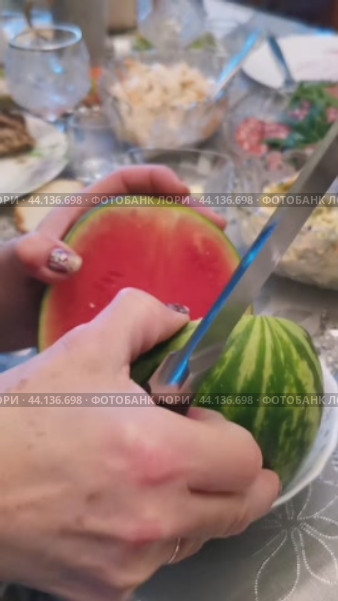 Женщина разрезает арбуз за праздничным столом. Стоковое видео, видеограф Краснова Ирина / Фотобанк Лори