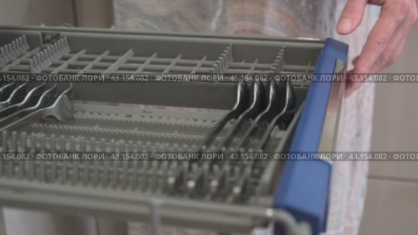 Женщина складывает столовые ложки в отсек посудомоечной машины. Стоковое видео, видеограф Вячеслав Александров / Фотобанк Лори