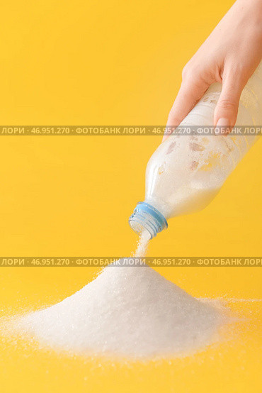 Женщина сыпет сахар из пластиковой бутылки на цветной фон. Стоковое фото, фотограф Pixel_shot / Фотобанк Лори