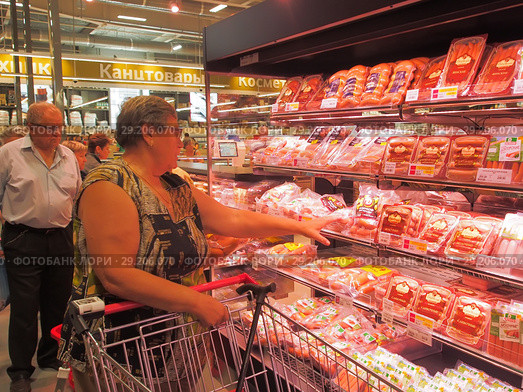 Женщина выбирает колбасную продукцию в торговом зале супермаркета Selgros Cash & Carry в Зеленограде в день открытия (2018 год). Редакционное фото, фотограф Сайганов Александр / Фотобанк Лори