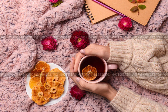 Женские руки с чашкой чая, сухофруктами и цветами на фоне ткани. Стоковое фото, фотограф Pixel_shot / Фотобанк Лори