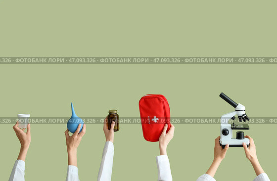 Женские руки с микроскопом, клизмой, таблетками и аптечкой на зеленом фоне. Стоковое фото, фотограф Pixel_shot / Фотобанк Лори