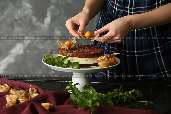 Женский кондитер украшает вкусный торт за столом. Стоковое фото, фотограф Pixel_shot / Фотобанк Лори