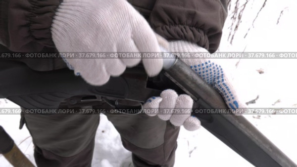 Зимняя охота. Охотник заряжает гладкоствольное ружьё. Winter hunting. The hunter loads a smoothbore rifle. Стоковое видео, видеограф Евгений Романов / Фотобанк Лори