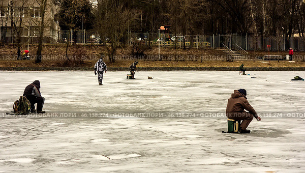 Зимняя рыбалка в черте города Москва/ Men ice fishing on a frozen lake. Men engaged in winter fishing on the lake in Moscow, Russia. Редакционное фото, фотограф Iva Noel / Фотобанк Лори