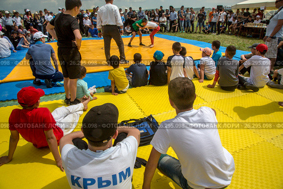 Зрители и борцы во время турнира по крымскотатарской национальной борьбе «Куреш» на традиционном крымскотатарском празднике Хыдырлез в Бахчисарайском районе, Республика Крым (2017 год). Редакционное фото, фотограф Николай Винокуров / Фотобанк Лори